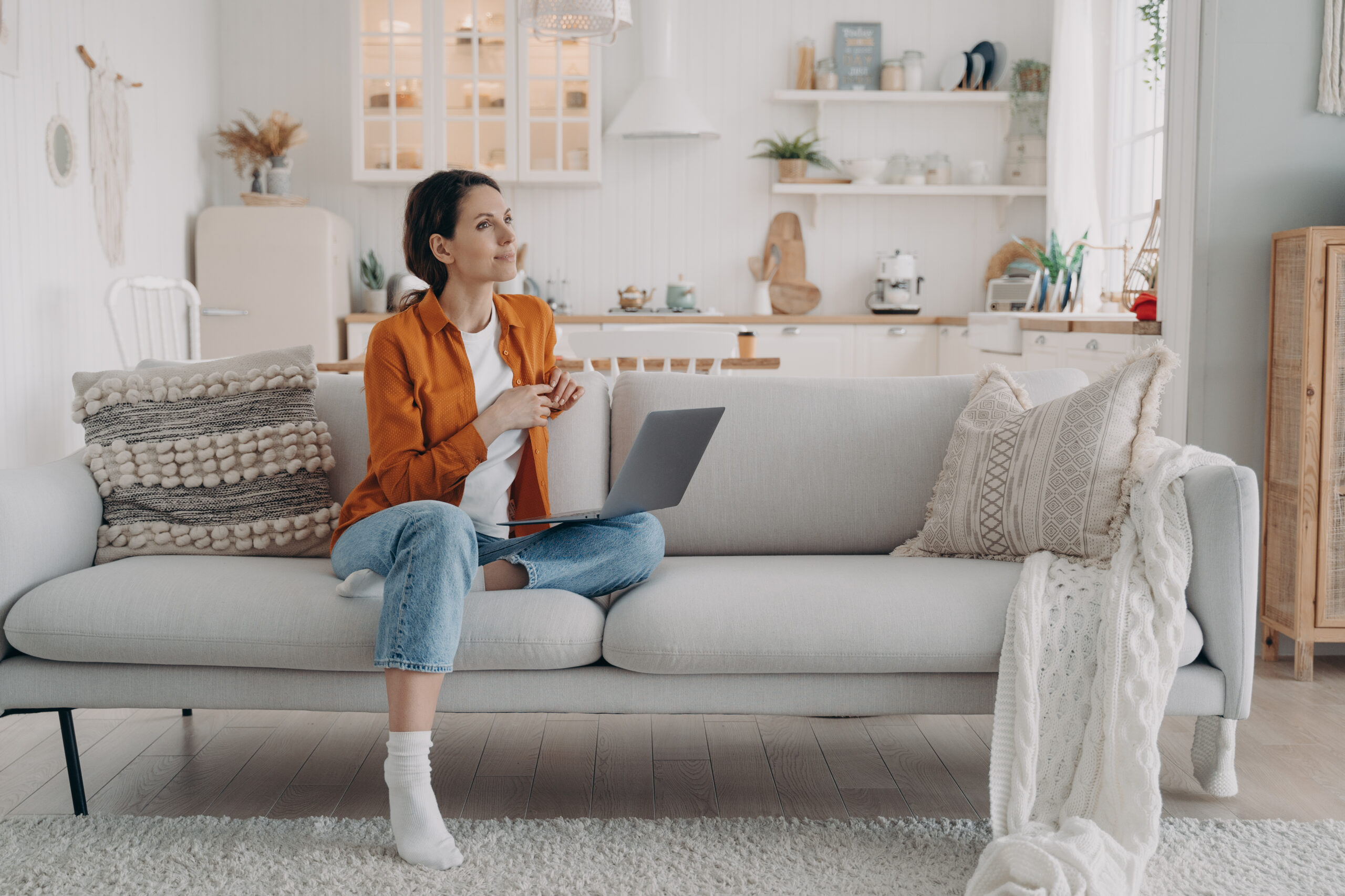 Woman relaxing with laptop in modern living room